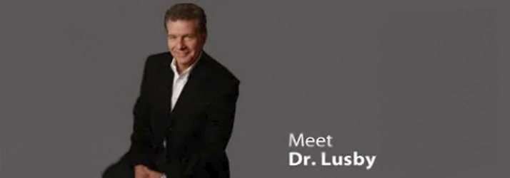 Professional introduction slide featuring Dr. Lusby against a plain gray background.